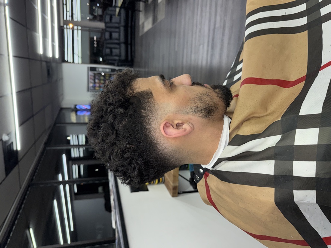 Curly top with a low taper fade from Slick Fades